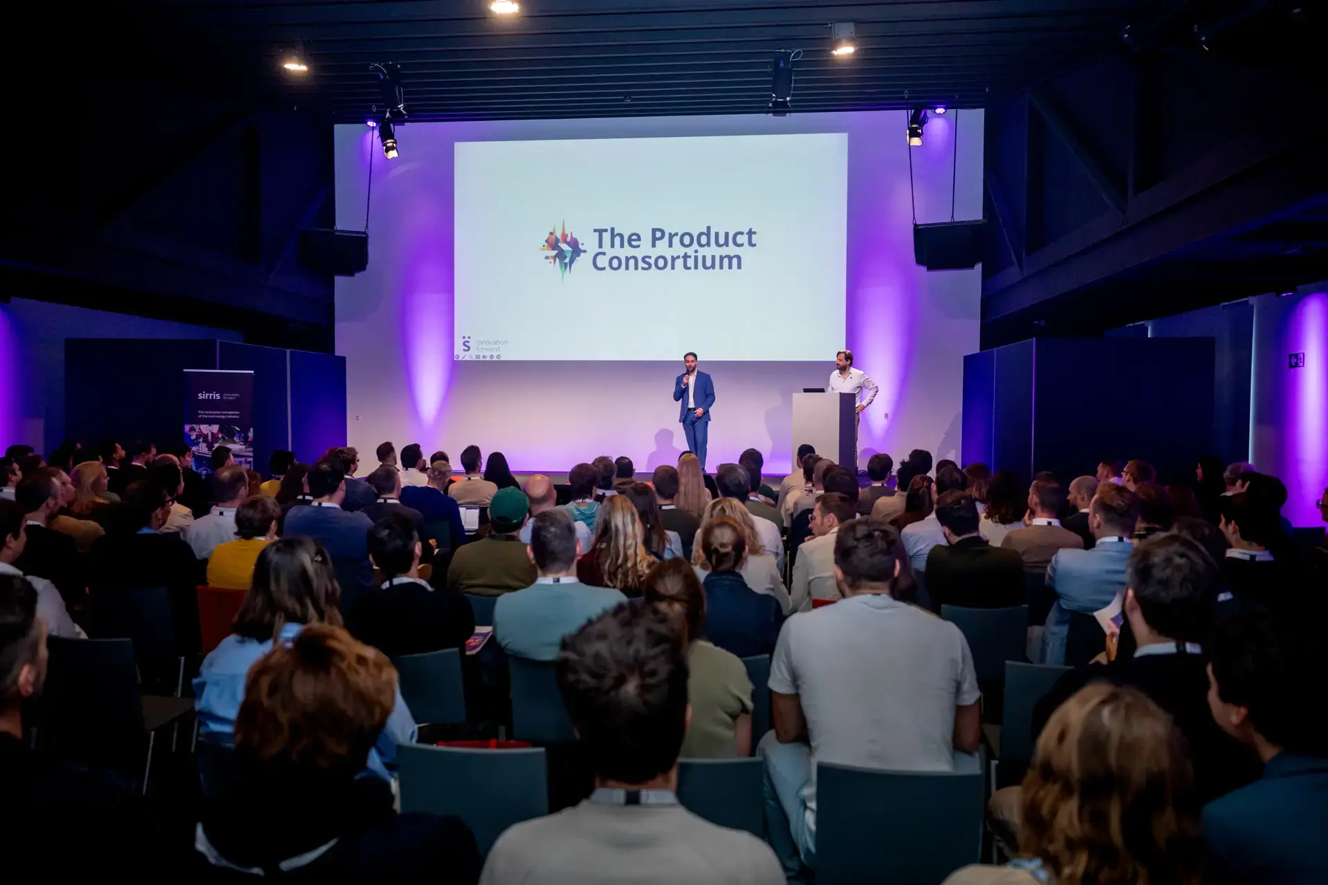 Atmospheric black and white photo of people in a dark industrial meeting space
